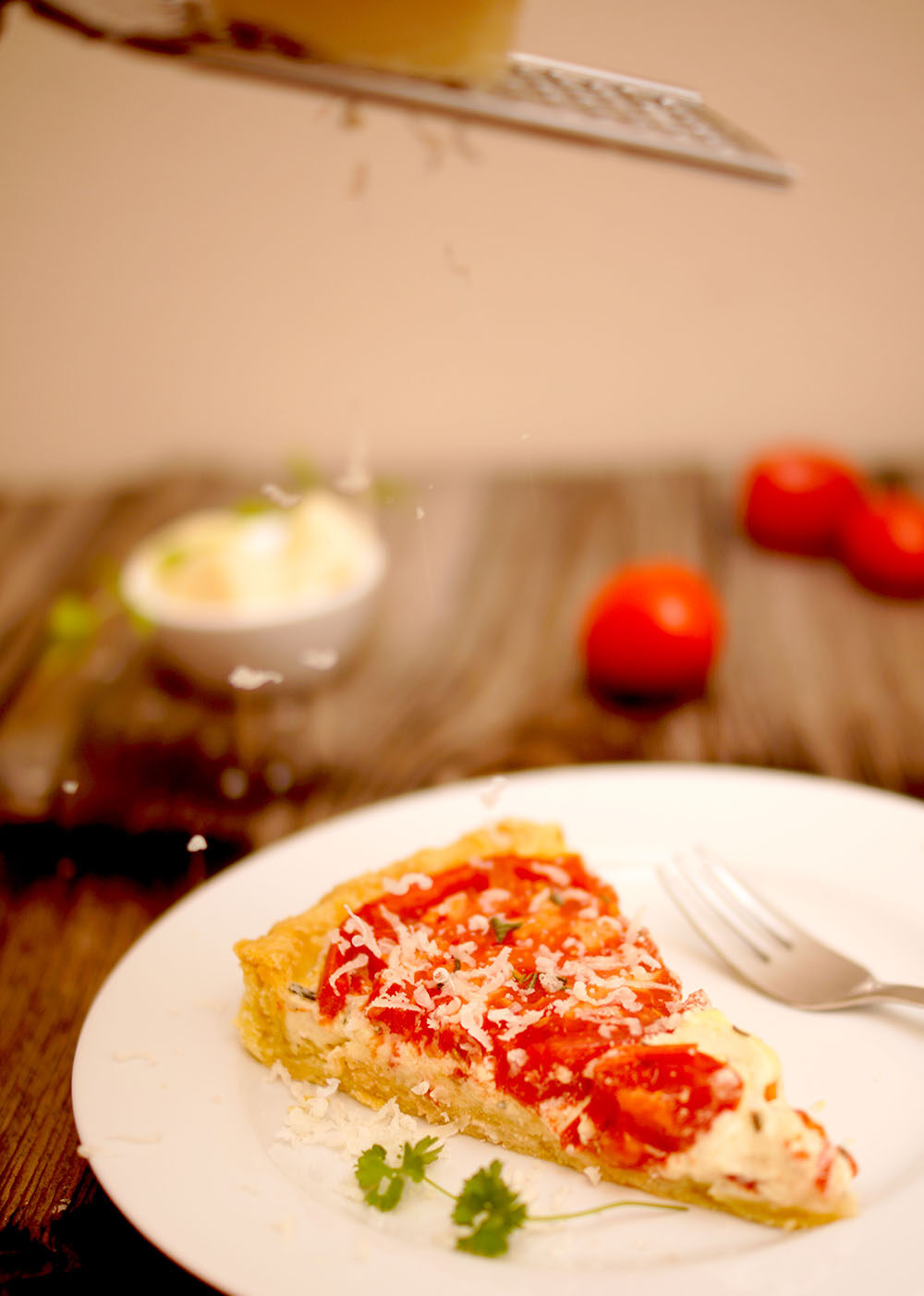 Frisch geriebenen Parmesan über Tarte raspeln