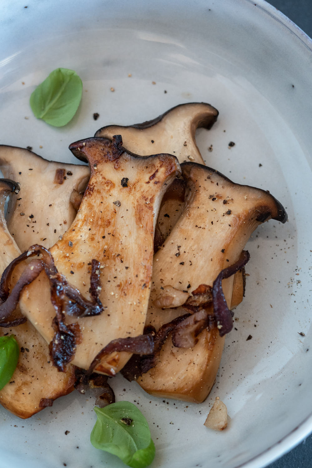 Angebratene Kräuterseitlinge mit roten Zwiebeln und Knoblauch