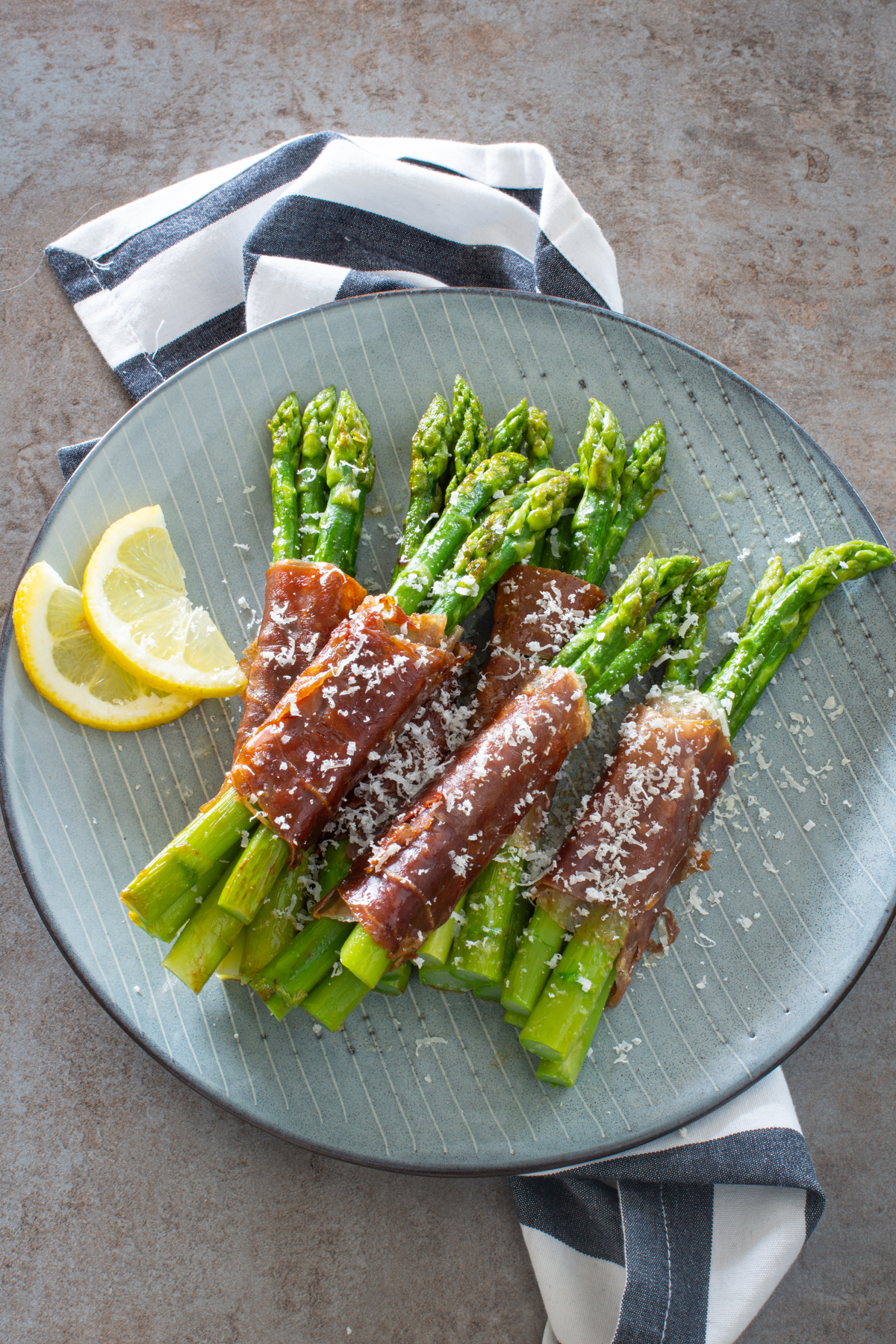 Grüner Spargel im Speckmantel mit einem Schuss Zitrone und Parmesan