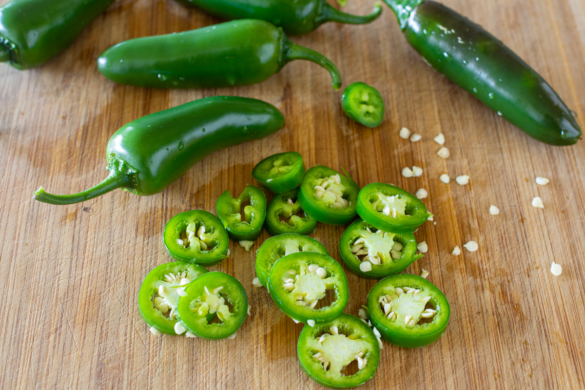 Jalapenos waschen, dann in Scheiben schneiden und in Gläser füllen
