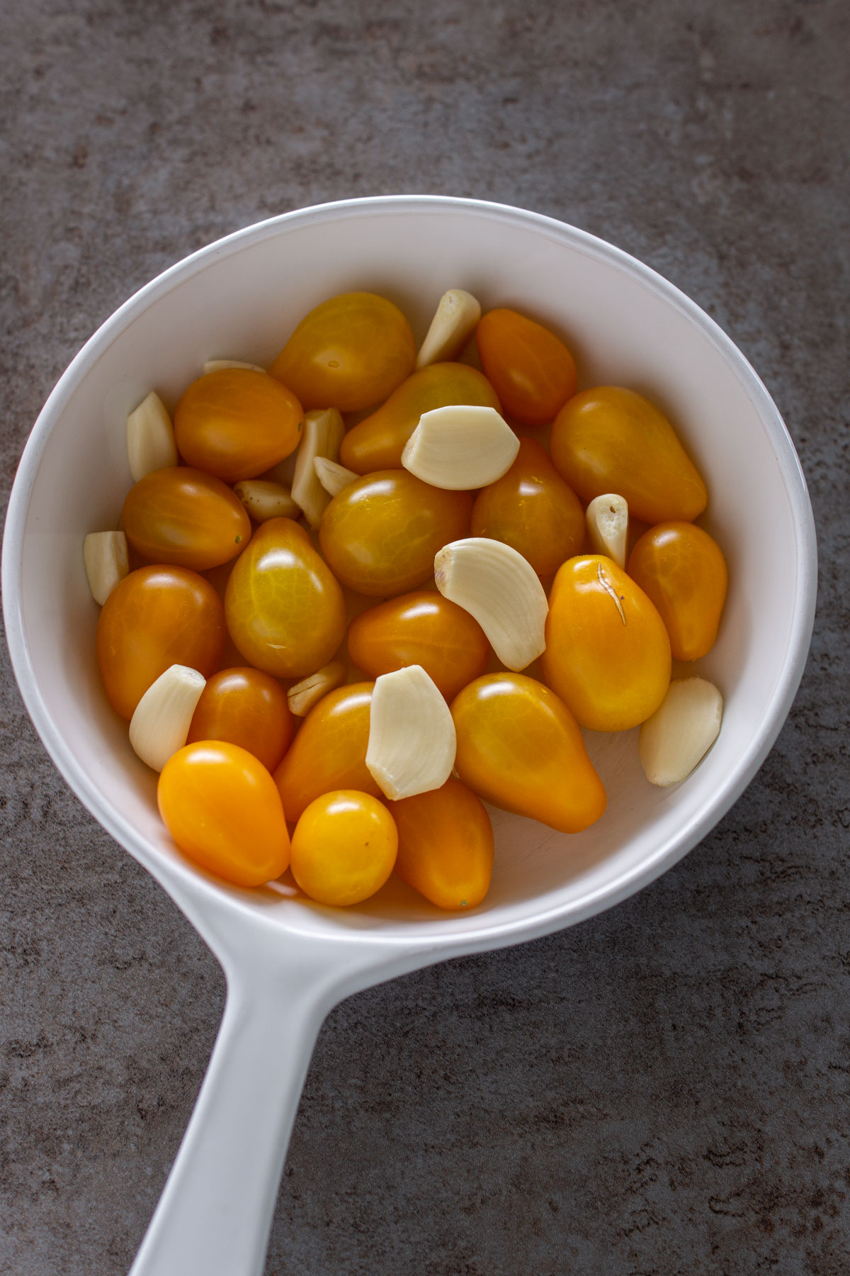 Tomaten und Knoblauch in eine ofenfeste Form geben.